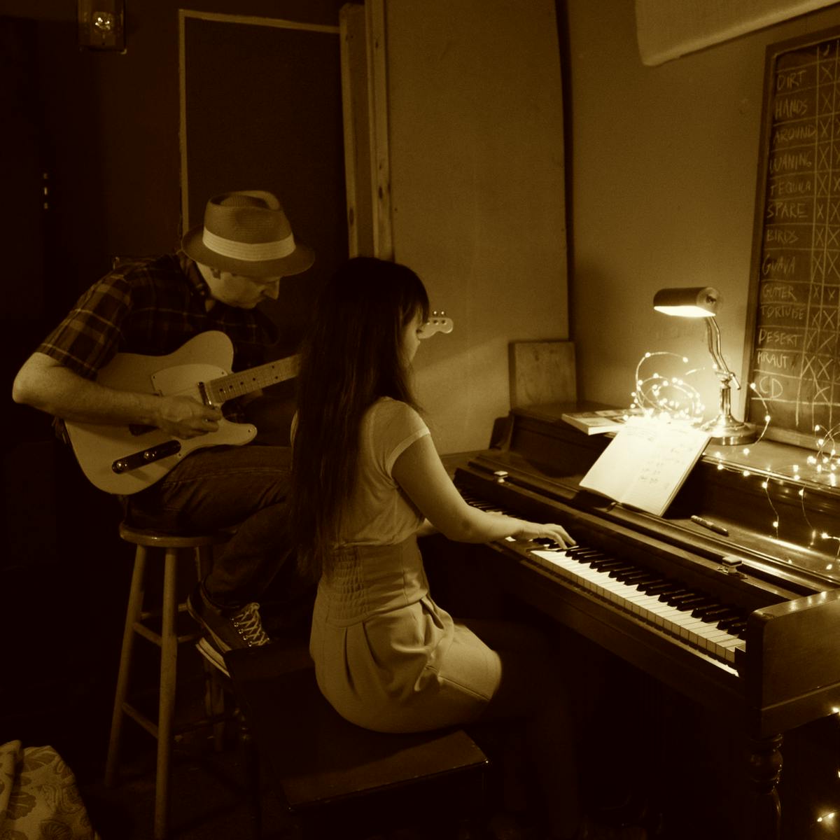 Papá enseñando a su hija a tocar la guitarra
