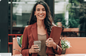 Una mujer sosteniendo una carpeta archivadora y una taza de café