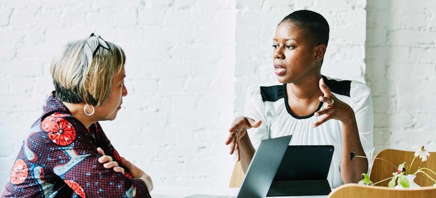 [Featured image] Two women in a meeting discussing human resources and employee retention