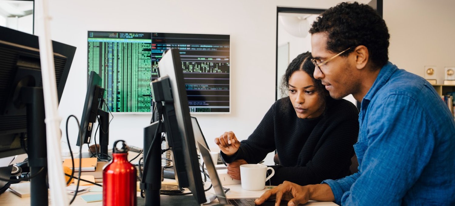 Two coworkers focus on a project at a company with a successful learning culture.