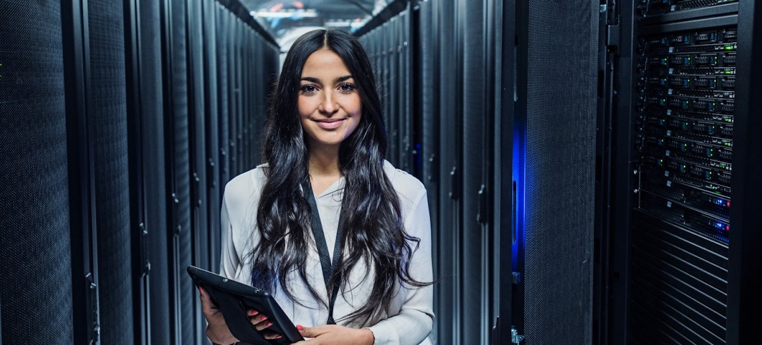[Featured image] Woman standing in server room with tablet