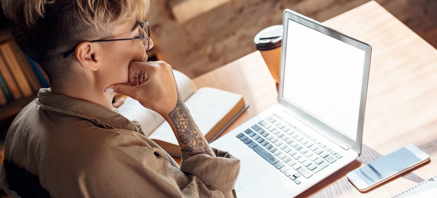 [Featured image] A person with glasses and a tattooed arm looks at their laptop.