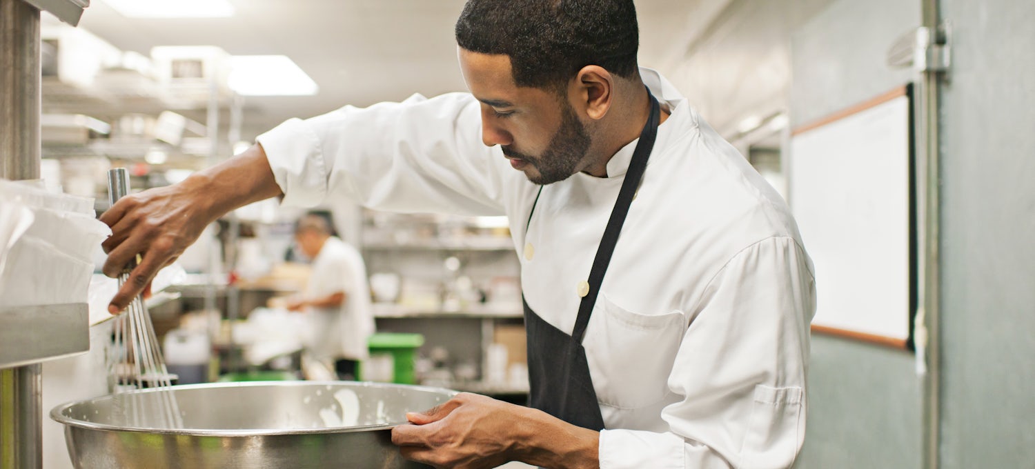 [Featured Image] A head chef combines food in a commercial kitchen after learning about California jobs in demand and applying their training and passion for culinary arts.  

