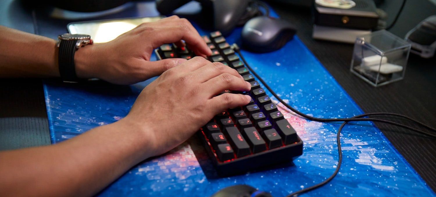 [Featured Image] Two hands type on a desktop keyboard.