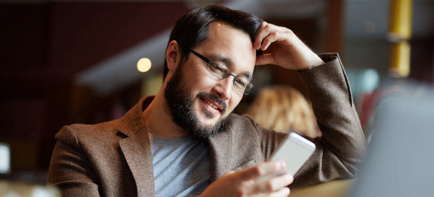 [Featured image] Man on phone reading marketing blog