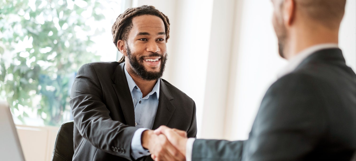 [Imagen destacada] Dos hombres se dan la mano en una reunión de negocios sobre marketing B2B.