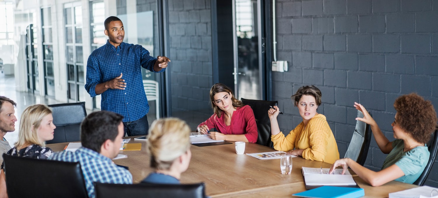 [Featured image] A man in a blue shirt leads a DevOps meeting.