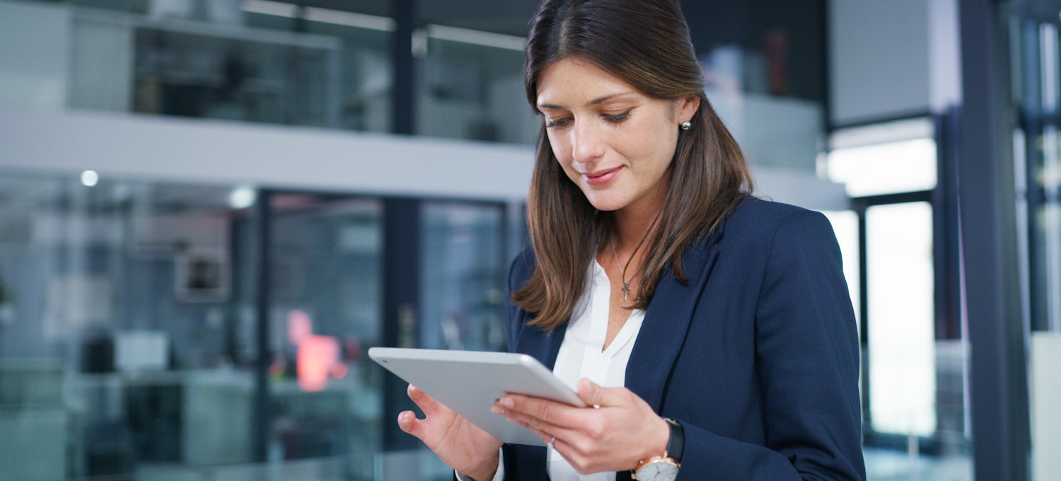 [Featured Image] A business woman uses MDM software on her tablet. 