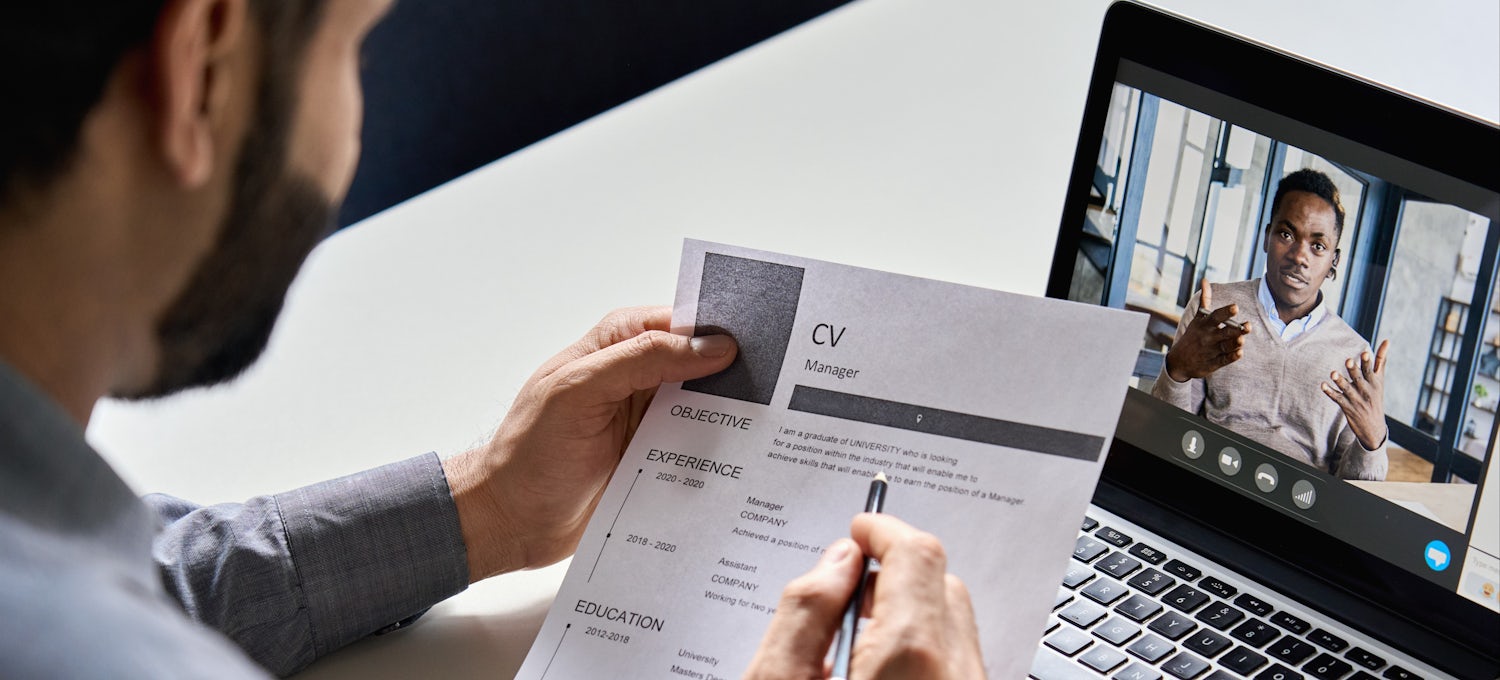 [Featured image] A hiring manager reviewing an CV with a video applicant