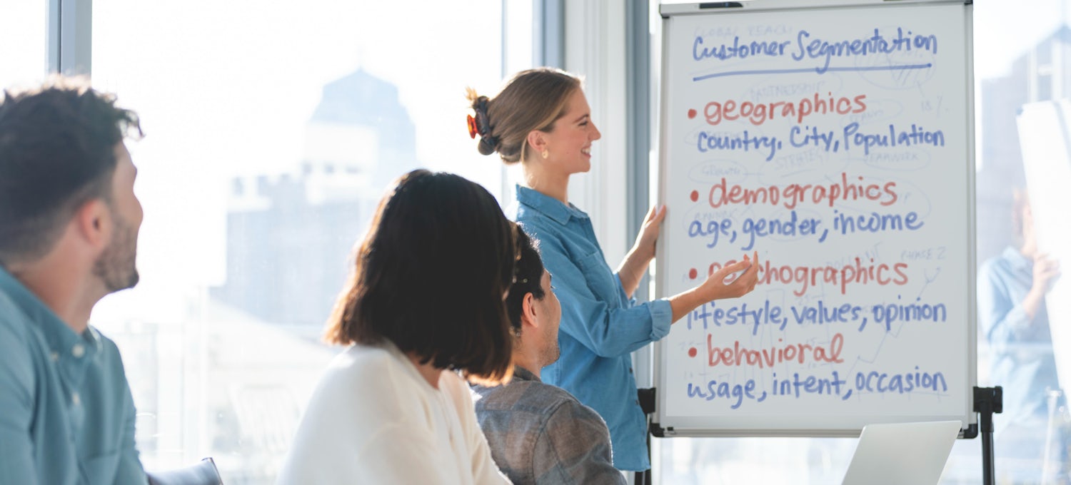 [Featured image] A marketing manager writes on a whiteboard where the words "customer segmentation" are written.