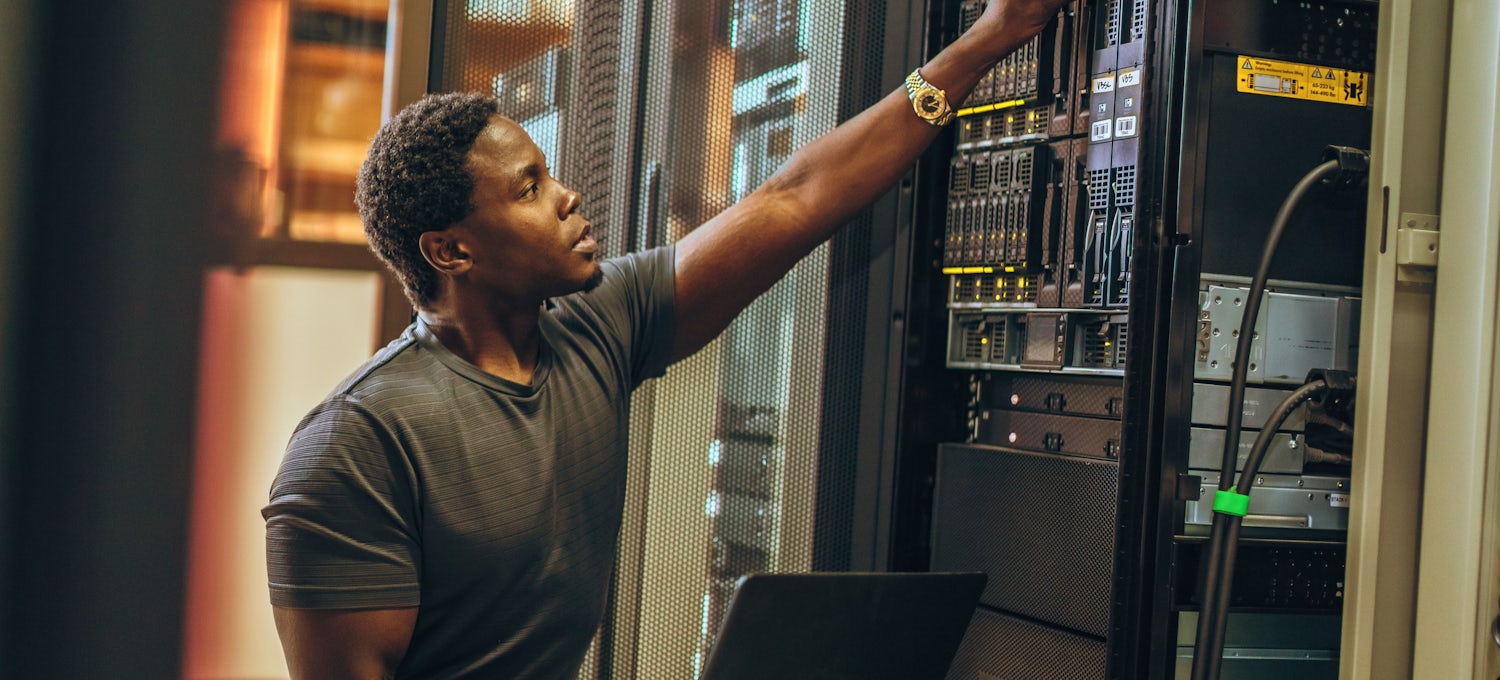[Featured image] An IT technician works on a server in a data center.
