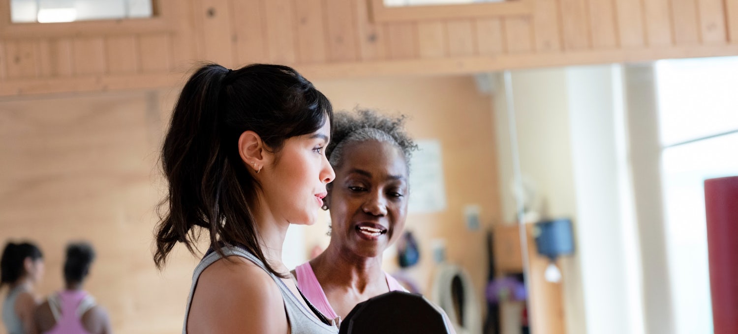 [Featured Image]: Physiotherapist working with a patient in a clinic, using weights.