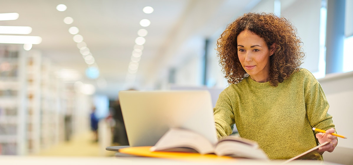 Person in green jumper sat at desk