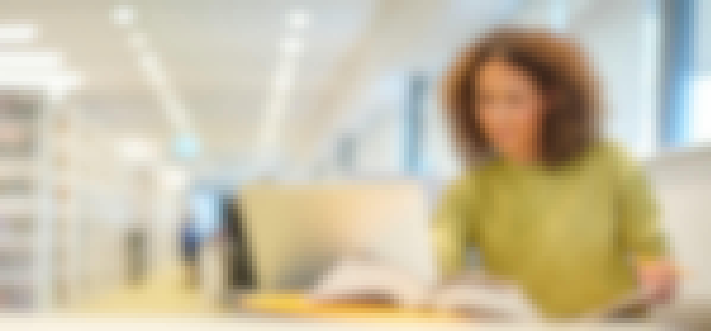 Person in green jumper sat at desk