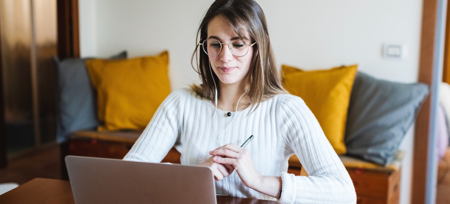 [Featured Image]: A law degree student wearing glasses and a white sweater sits in front of her computer screen and holding a pen.