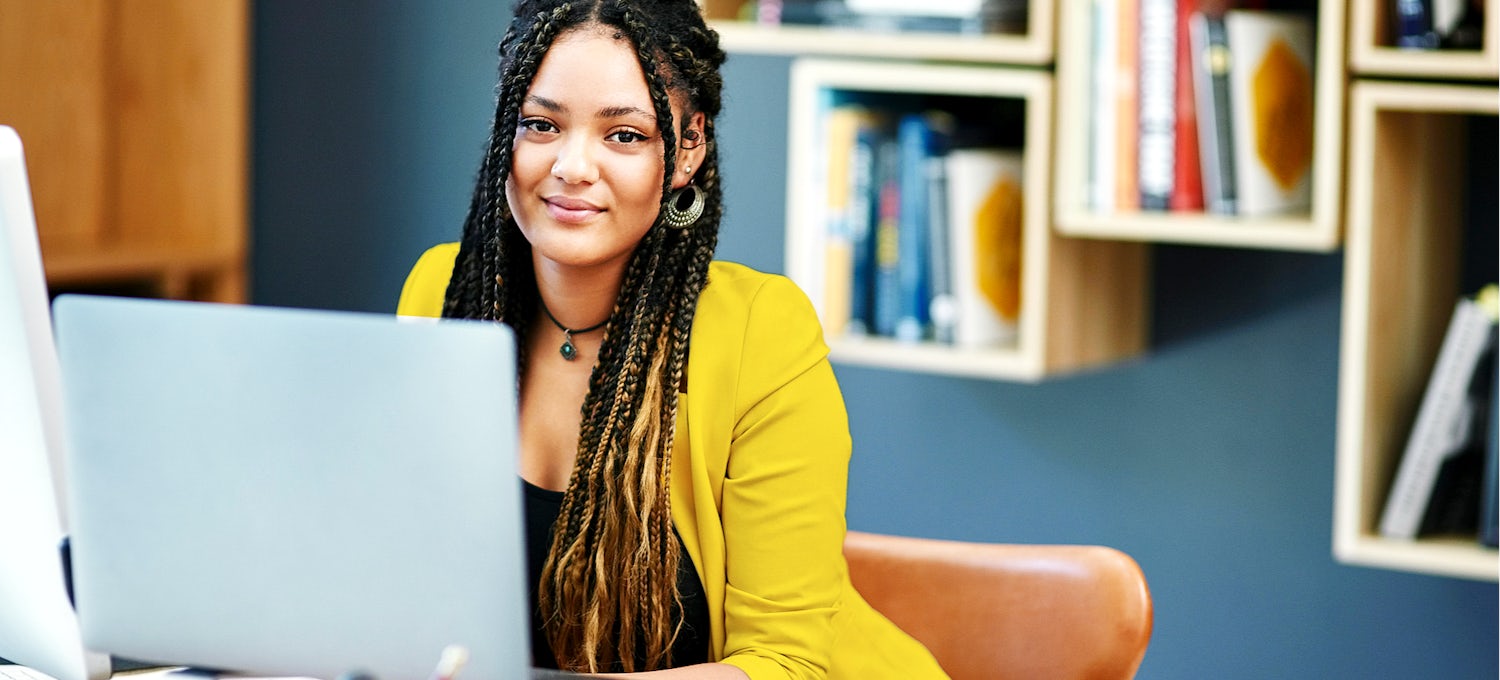 [Featured image] A paralegal in a yellow jacket works on a laptop computer.