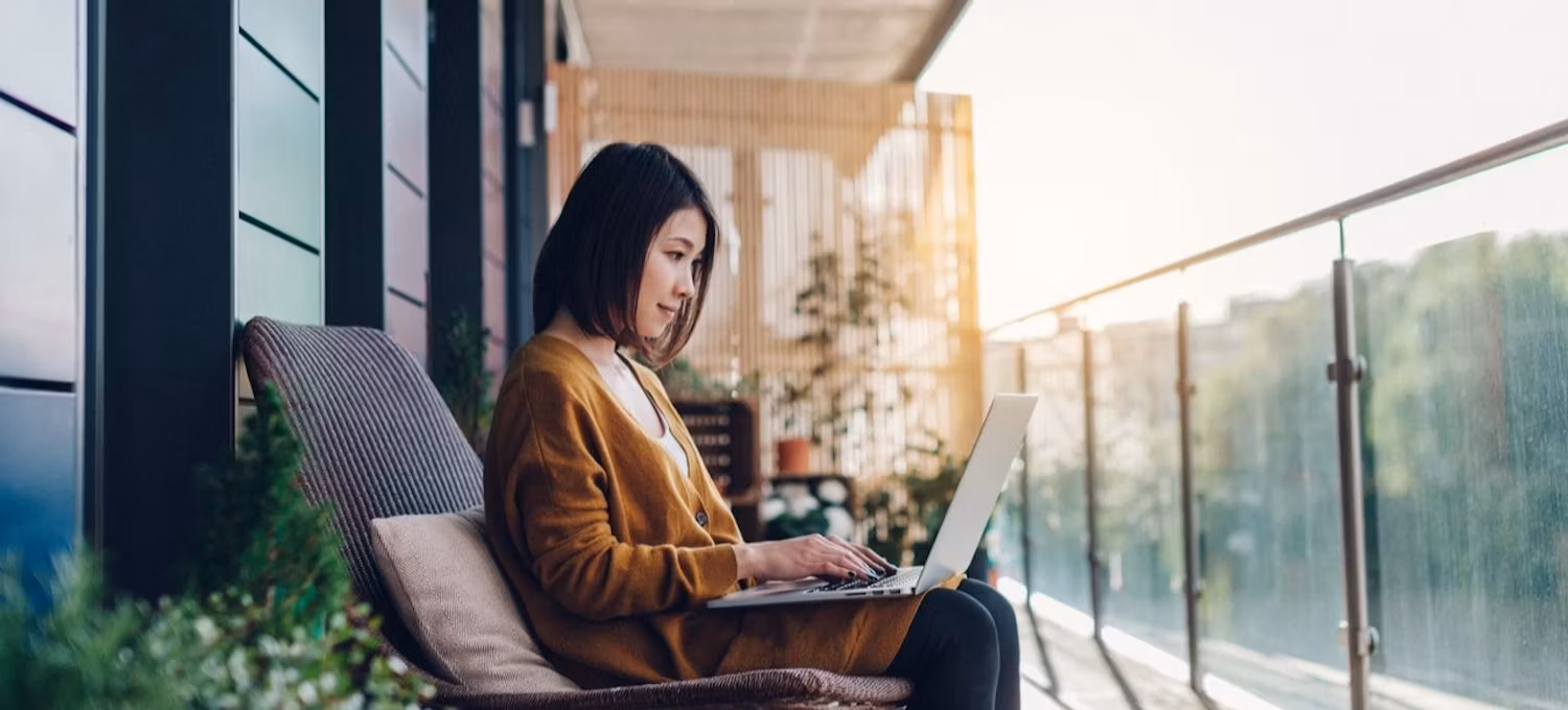 Un spécialiste de l'assistance informatique se trouve sur un balcon et utilise son ordinateur portable pour s'informer sur l'IPv6.